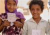 14 million infants worldwide remain unvaccinated Two children hold their vaccination cards after receiving the oral cholera vaccine in Sannah camp in Al Dhale'e, Yemen. Photo: WHO EMRO