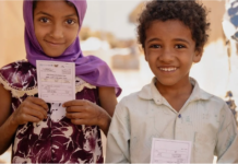 14 million infants worldwide remain unvaccinated Two children hold their vaccination cards after receiving the oral cholera vaccine in Sannah camp in Al Dhale'e, Yemen. Photo: WHO EMRO