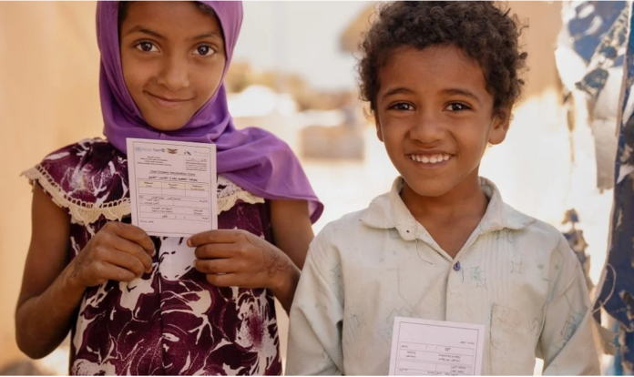 vaccine Two children hold their vaccination cards after receiving the oral cholera vaccine in Sannah camp in Al Dhale'e, Yemen. Photo: WHO EMRO